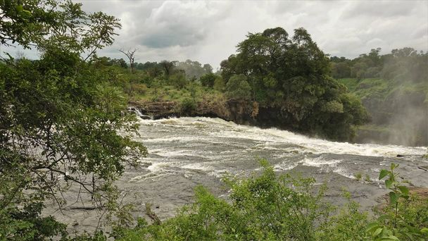 Ο ποταμός Ζαμπέζι ρέει γρήγορα πριν πέσει στην άβυσσο. Αφρός στο νερό. Ομίχλη στον αέρα. Πλούσια τροπική βλάστηση τριγύρω. Βικτόρια Φολς. Ζιμπάμπουε - Φωτογραφία, εικόνα