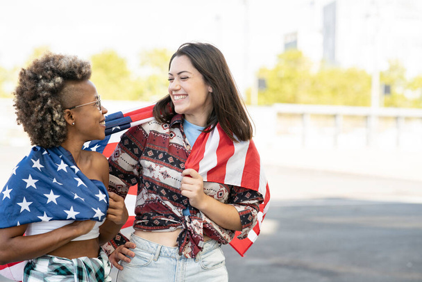friends cover themselves with the United States flag - 写真・画像
