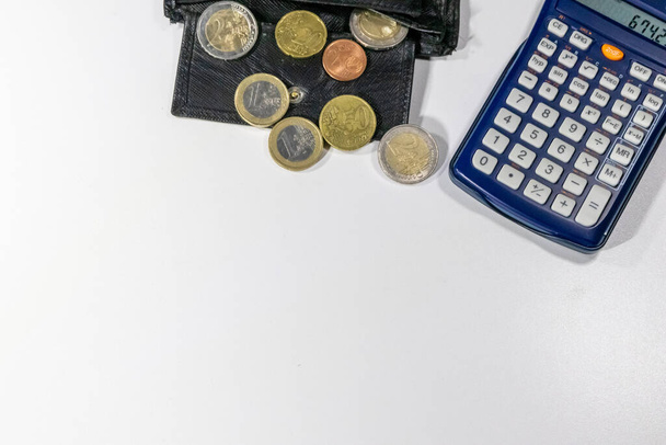 European money with black wallet on white desk as white background with different euro coins and euro bank notes with calculator for financial management and income business plans for tax calculation - Photo, Image