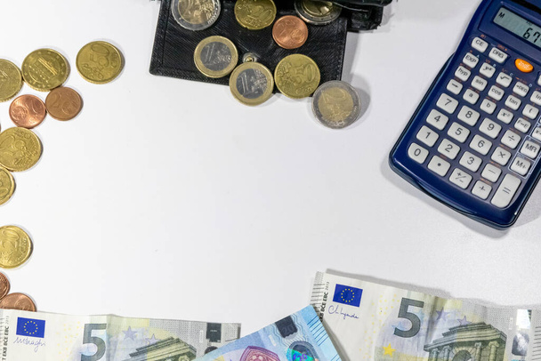 Eurooppalainen raha mustalla lompakolla valkoisella pöydällä valkoisena taustana erilaiset eurokolikot ja eurosetelit laskurilla taloushallintoa ja tulolaskelmia varten - Valokuva, kuva