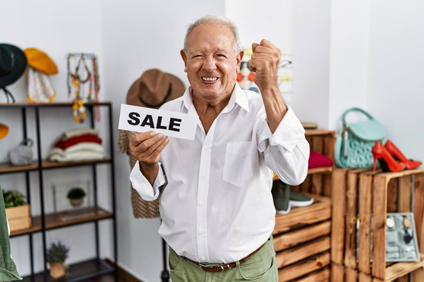 Starszy mężczyzna z chorągwią sprzedaży w sklepie detalicznym zirytowany i sfrustrowany krzycząc z gniewu, wrzeszcząc szalony z gniewu i podniesione ręce  - Zdjęcie, obraz