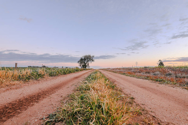 zachód słońca na drodze krajowej w Central Victoria, Australia. Późnym popołudniem w Australii. Obraz krajobrazu, - Zdjęcie, obraz