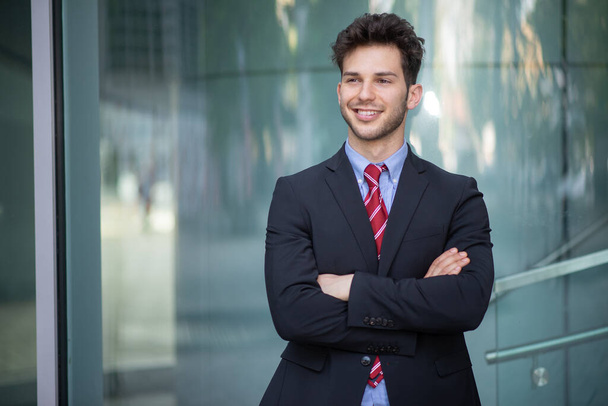 Hymyilevän liikemiehen muotokuva sinisen modernin taustan edessä - Valokuva, kuva