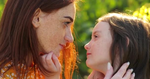 rothaarige Mutter und rothaarige Tochter mit Zwickel im Gesicht schauen einander genau an - Filmmaterial, Video