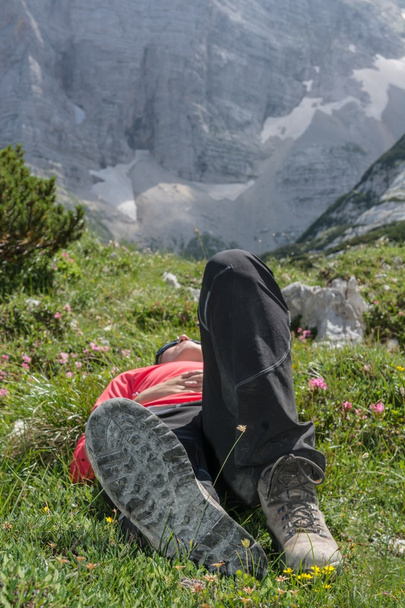 Jovem relaxante em um prado de montanha
 - Foto, Imagem