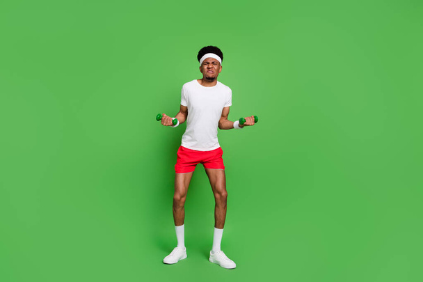 Full length body size view of trendy attractive weak guy sportsman doing exercise isolated over bright green color background - Foto, Imagen