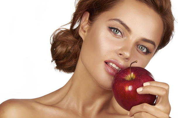 Young beautiful sexy girl with dark curly hair, bare shoulders and neck, holding big red apple to enjoy the taste and are dieting, healthy eating and organic foods, feeling temptation, smile, teeth - Foto, Imagem