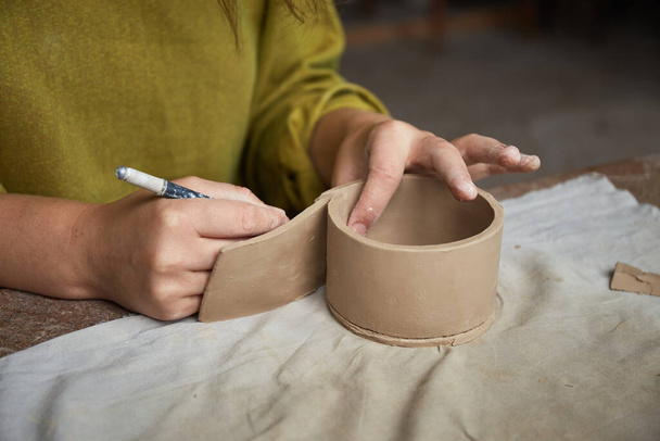 Keramička pracující v keramickém studiu. Keramické ruce Špinavé hlíny. Proces vytváření keramiky. Master keramik pracuje ve svém studiu - Fotografie, Obrázek