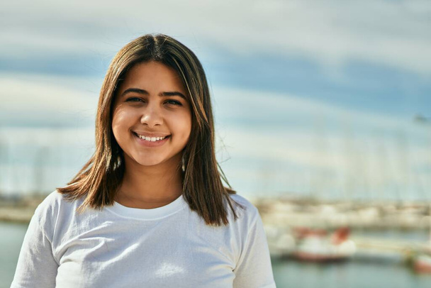 Nuori latino tyttö hymyilee onnellinen seisoo rannalla. - Valokuva, kuva