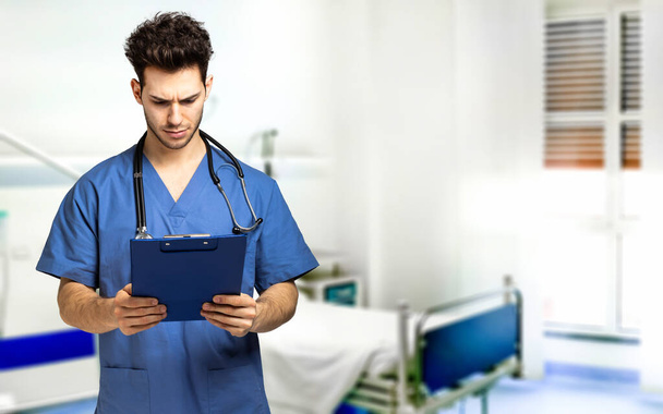 Male nurse reading a clipboard in hospital  - Foto, immagini