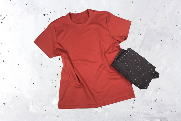Blanke rote weinrote T-Shirt-Attrappe auf grauem Hintergrund.  - Foto, Bild