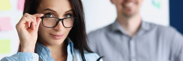 Ritratto di giovane donna consulente aziendale sullo sfondo di un collega di sesso maschile in carica - Foto, immagini