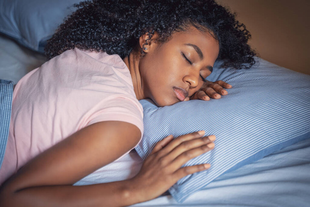 Zdrowa młoda afrykańska dziewczyna śpi w wygodnym łóżku - Zdjęcie, obraz