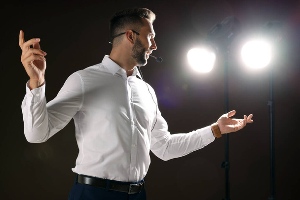 Motivational speaker with headset performing on stage - 写真・画像