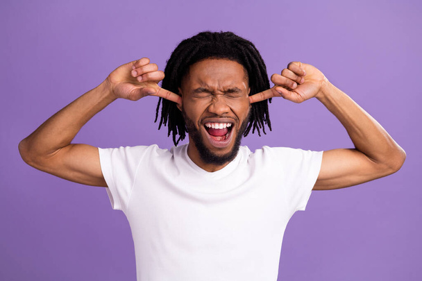 Portrait of attractive desperate guy closing ears shouting isolated over bright violet lilac purple color background - 写真・画像