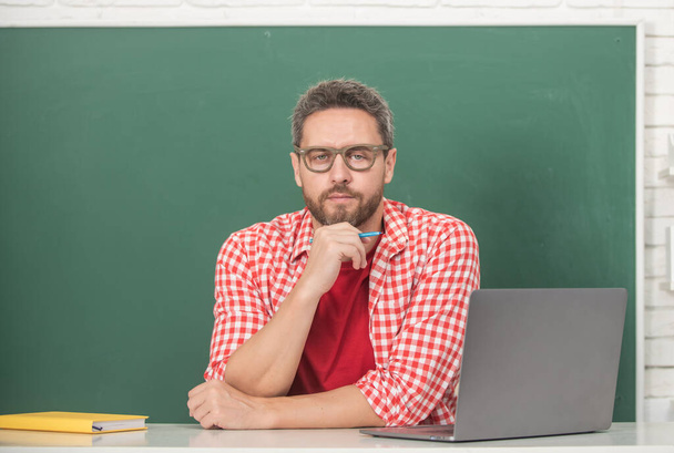 День учителя. наставник в очках с ноутбуком. взрослые студенты учатся онлайн. - Фото, изображение