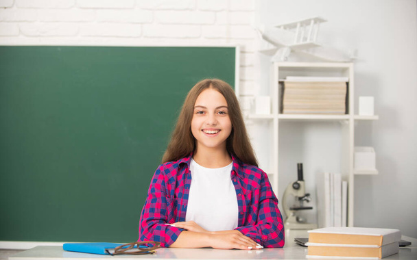 Un'adolescente sorridente torna a scuola. giorno della conoscenza. concetto di istruzione. bambino in classe - Foto, immagini