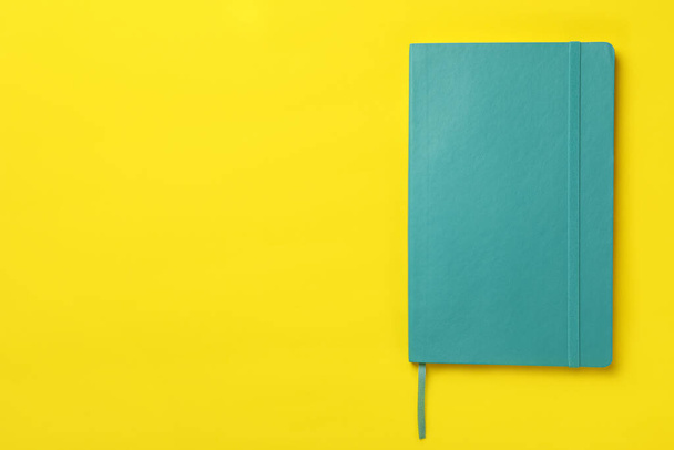 New stylish planner with hard cover on yellow background, top view. Space for text - Foto, afbeelding