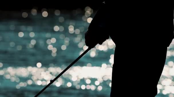 silhouette de pêcheur récupérer ligne de pêche sur moulinet de coulée. fond bokeh - Séquence, vidéo