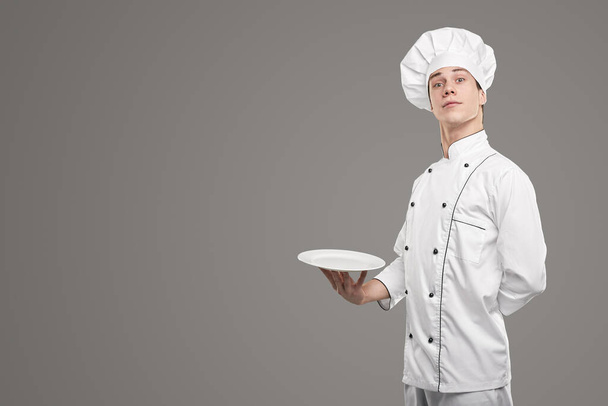 Young cook with empty plate - Foto, Imagen