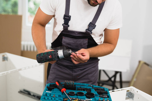 worker changing bit on cordless drill - Foto, imagen