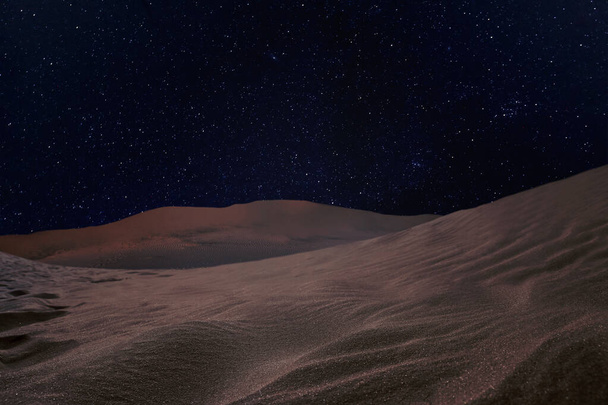 Landschappelijk uitzicht op zandwoestijn onder sterrenhemel in de nacht  - Foto, afbeelding