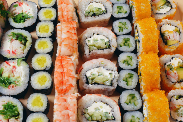 Маки и нигири, суши с рыбой, свежий лосось, креветки и сыр, роллы авокадо. Футомаки и Филадельфия с Калифорнией. Набор суши - Фото, изображение