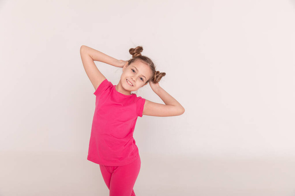 portrait of a beautiful girl with tails in pink clothes on a white isolated background. Copy space - Photo, image