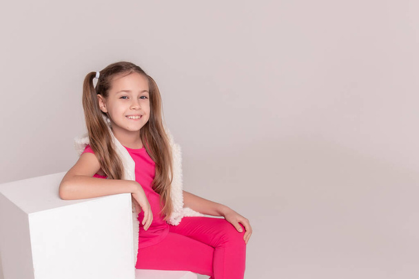 portrait of a beautiful girl with tails in pink clothes on a white isolated background. Copy space - Foto, immagini