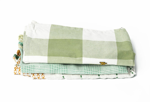 сложенное зеленое белье полотенце на белом фоне, вид сверху - Фото, изображение