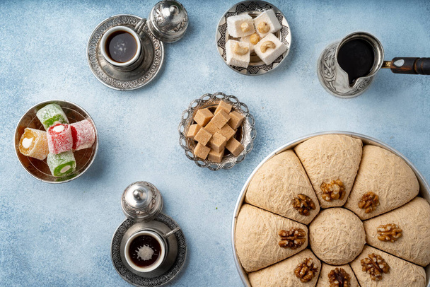 Top view of Turkish sweets and turkish coffee on light blue background - Photo, Image