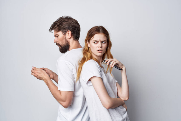 married couple in white T-shirts with phones in their hands isolated background - Fotó, kép