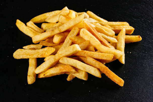 Franse frietjes op zwarte achtergrond - Foto, afbeelding