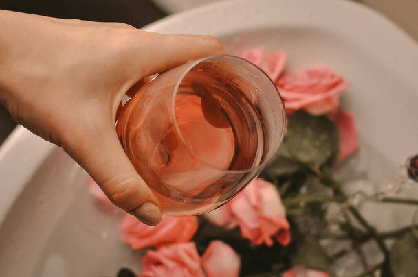 Lasi viiniä ja kukkakimppu vaaleanpunaisia ruusuja pesuallas - Valokuva, kuva