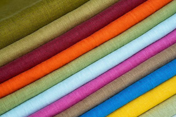 Стек різнокольорової яскравої лляної тканини, крупним планом. Лляний фон. Тканинні смуги
 - Фото, зображення