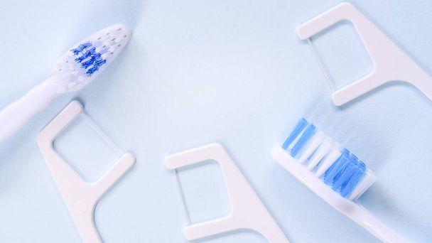 Blurred white-blue toothbrush and disposable dental floss. Daily rituals in the morning concept. High quality photo - Photo, Image