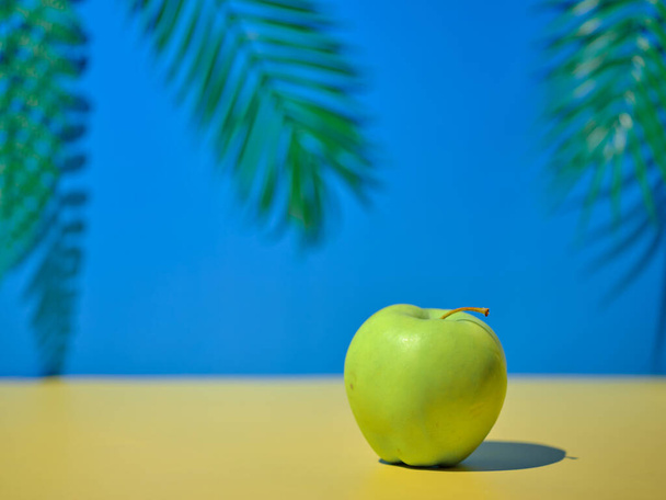 Зеленое яблоко на столе на естественном фоне - Фото, изображение