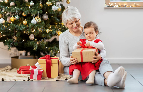 grandmother and baby girl with christmas gifts - Фото, изображение