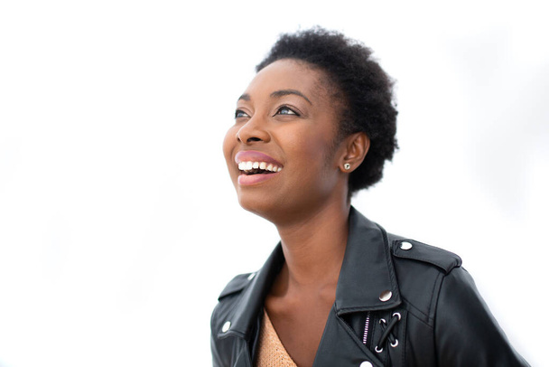Κοντινό πλάνο ειλικρινής πορτρέτο ευτυχισμένη νεαρή Αφροαμερικανή γυναίκα με δερμάτινο μπουφάν σε απομονωμένο λευκό φόντο  - Φωτογραφία, εικόνα