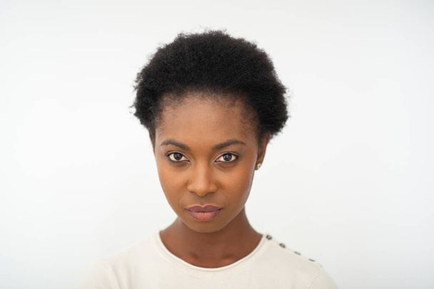 Primer plano retrato hermosa joven afroamericana cara seria expresión por blanco aislado fondo  - Foto, Imagen