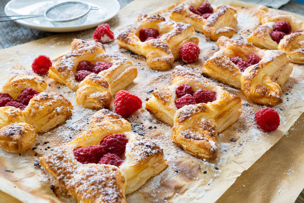 Puff pastry with raspberries on baking paper  - Φωτογραφία, εικόνα