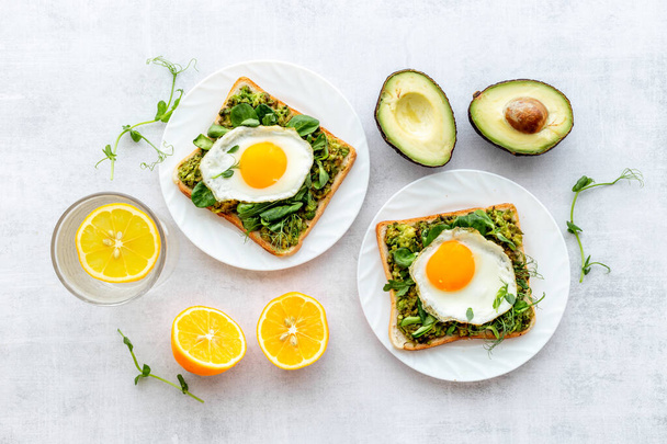 Toasts with avocado and fried eggs. Healthy breakfast - 写真・画像