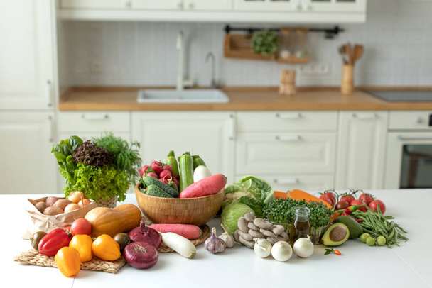 Verduras en la mesa en una hermosa cocina. - Foto, imagen