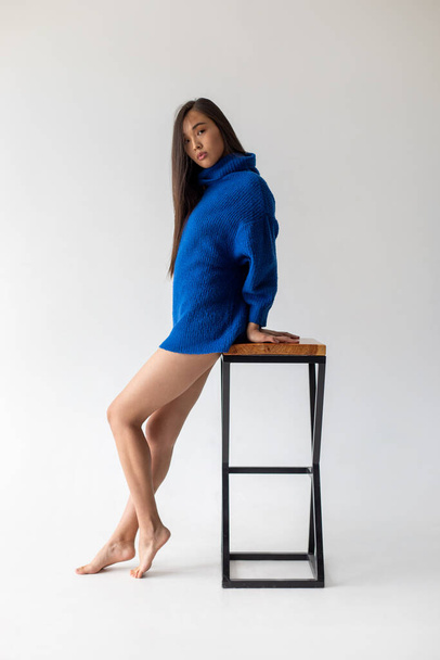Attractive asian woman in blue sweater on white background. Model tests. - Valokuva, kuva