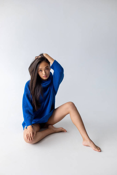 Attractive asian woman in blue sweater on white background. Model tests. - Foto, immagini