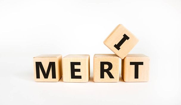 Merit symbol. The concept word 'merit' on wooden cubes on a beautiful white table. White background. Business and merit concept. - Zdjęcie, obraz