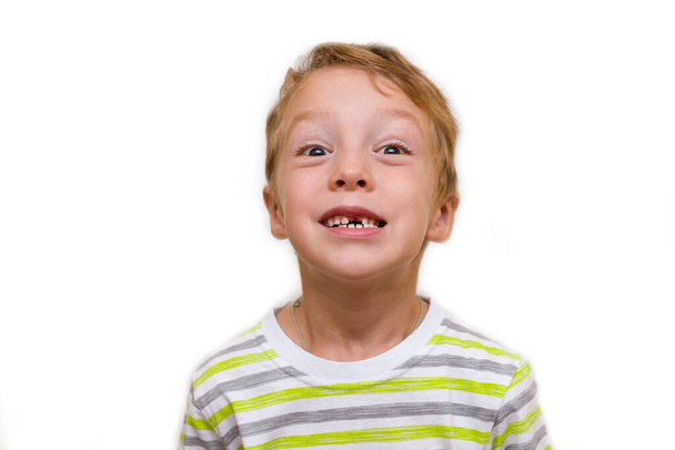 Poika hymyilee ilman hammasta. Lapsi on menettänyt ylemmän hampaan, lähikuva eristää valkoisella taustalla - Valokuva, kuva