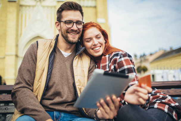 Trendy giovane coppia in città utilizzando tablet e carta di credito. - Foto, immagini