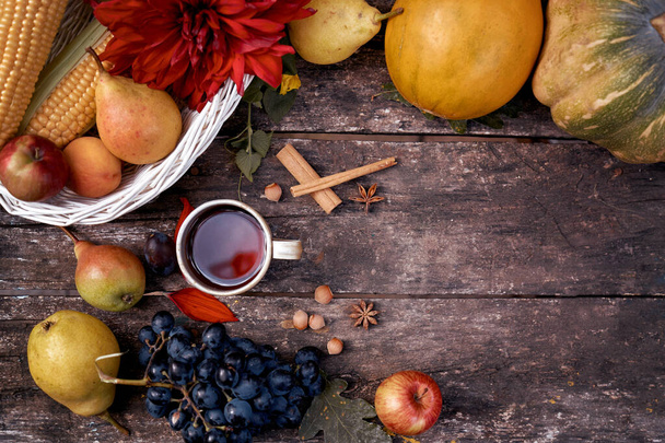 秋の素朴な静物画:お茶、果物、野菜、ヘーゼルナッツ、シナモンスティックのカップ。秋の審美的な居心地のよさ.感謝祭の日のコンセプトテキストの場所です。トップ表示 - 写真・画像