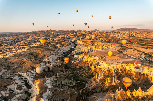 A beutoful shot of hot air balloons flying over a mountainous landscape - Φωτογραφία, εικόνα